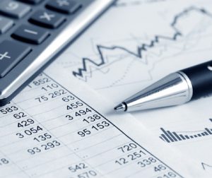 close up view of a pen, calculator, and accounting paperwork