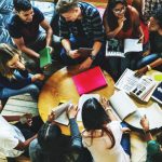 top down view of a group of students studying around a small table.