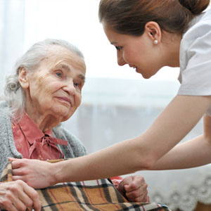 Nurse Aide assisting an elderly woman.