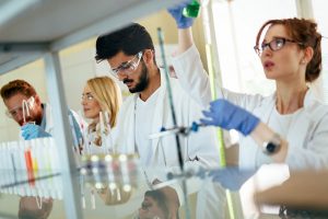 group of scientists working with vials