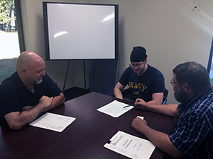 student, instructor, and employer going over paperwork for the WBL opportunity