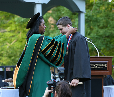 ance-Granville Community College President Dr. Stelfanie Williams places a medallion around the neck of Academic Excellence Award recipient Andrew Lynam of Youngsville