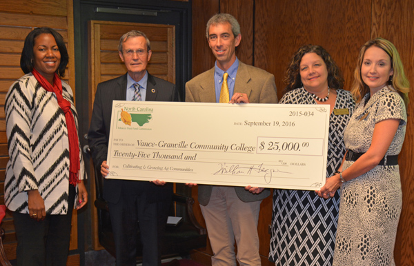 Jeff Camden, program officer for the North Carolina Tobacco Trust Fund Commission, center, presents a symbolic check for $25,000 to Vance-Granville Community College at the board meeting on Sept. 19 to support tuition and fees for students in the “Cultivating and Growing Agricultural Communities” project. Shown from left are Dr. Stelfanie Williams, VGCC’s president; Danny W. Wright, chair of the board of trustees; Camden; Kyle Burwell, VGCC’s coordinator of Human Resources Development; and Tanya Weary, VGCC’s director of the Small Business Center.