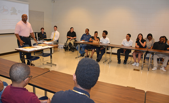 Lyndon Hall (standing), dean of the VGCC Warren County Campus, welcomes students participating in the National Summer Transportation Institute, many of whom were accompanied by parents and other family members on the first morning. 