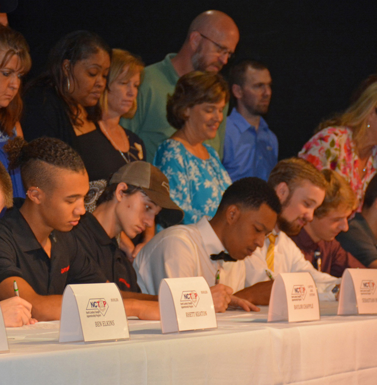 Students sign papers to join the NC Triangle Apprenticeship Program