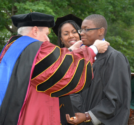 N.C. Community College System President Dr. Jimmie Williamson (left) places a medallion around the neck of Academic Excellence Award recipient Paul Caroline (right), with VGCC President Dr. Stelfanie Williams (center) looking on.