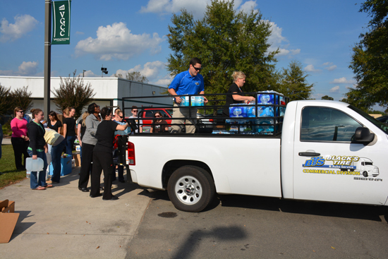 Radiography students load bottles of water and other supplies onto a Black’s Tire & Auto Service truck. 