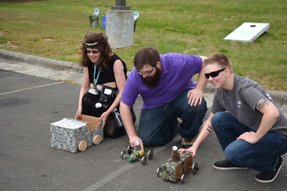 From left, VGCC South Campus staffers Geraldine Cash and Jonathan Jackson and student Mia Heath of Oxford prepare to race their homemade “pine cone cars” during an Earth Day event. 