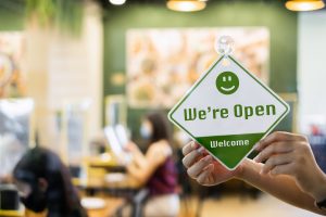 Store front with "We're Open Welcome" sign.