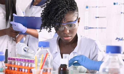 Student working in a biolab with beakers and test tubes