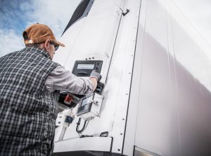 Refrigeration Technician checking a monitor on a large refrigeration unit