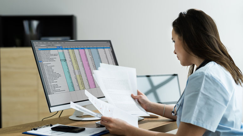 Medical Coder at a computer reviewing patient information