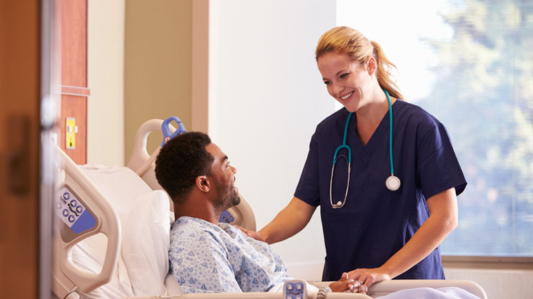 Nurse aide at bedside of patient.