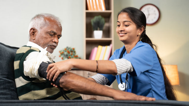 Nurse Aide checking a patient's blood pressure.