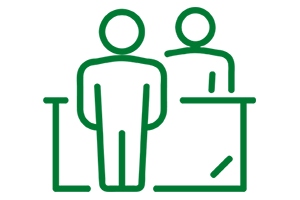 Clipart of a person standing in front of a desk while another person stands behind the desk.